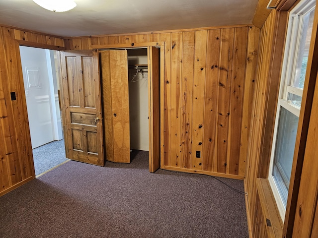 8867 W Garfield Rd, Shelby, MI 49455 - unfurnished bedroom with carpet flooring, wood walls, and a closet