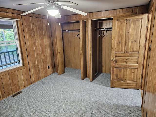8867 W Garfield Rd, Shelby, MI 49455 - carpeted bedroom featuring wooden walls, two closets, and ceiling fan