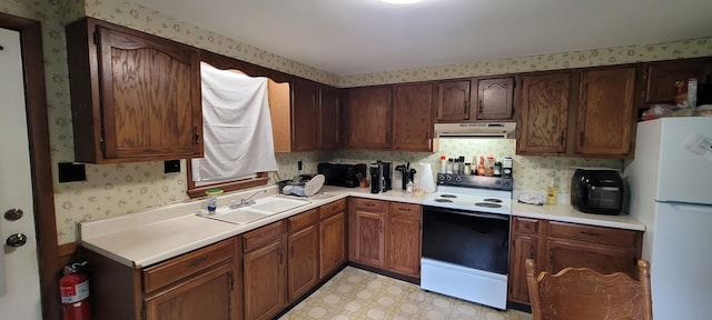 8867 W Garfield Rd, Shelby, MI 49455 - kitchen with white appliances, under cabinet range hood, wallpapered walls, light countertops, and light flooring