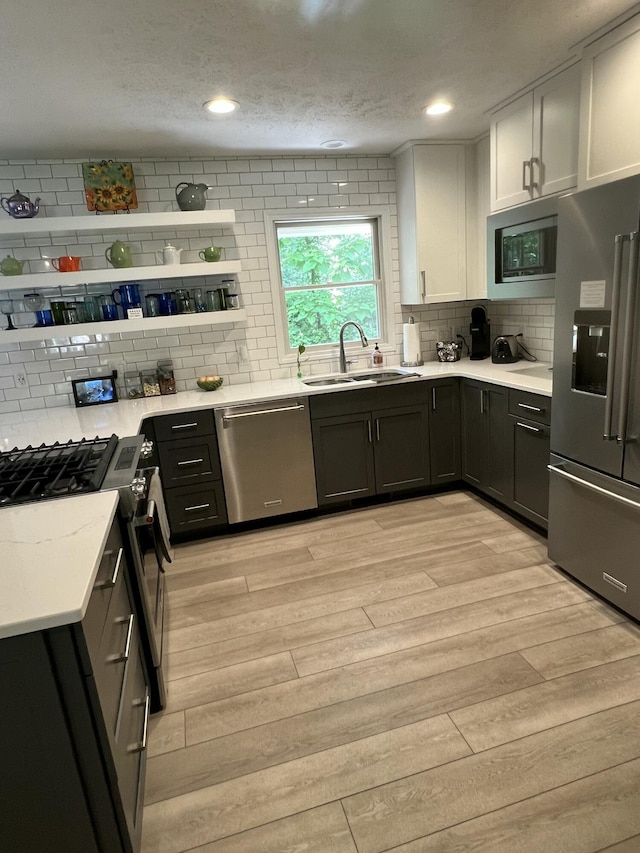 5437 Grand River Dr NE, Grand Rapids, MI 49525 - kitchen featuring appliances with stainless steel finishes, light wood-style flooring, backsplash, light countertops, and white cabinetry