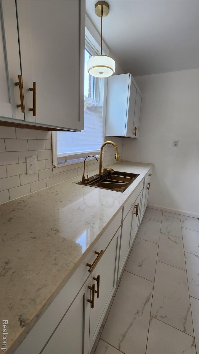 10947 Roxbury St, Detroit, MI 48224 - kitchen featuring decorative backsplash, light marble finish floors, light stone counters, pendant lighting, and white cabinets