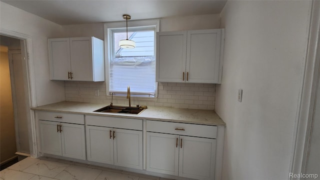 10947 Roxbury St, Detroit, MI 48224 - kitchen with tasteful backsplash, light marble finish floors, decorative light fixtures, and white cabinetry