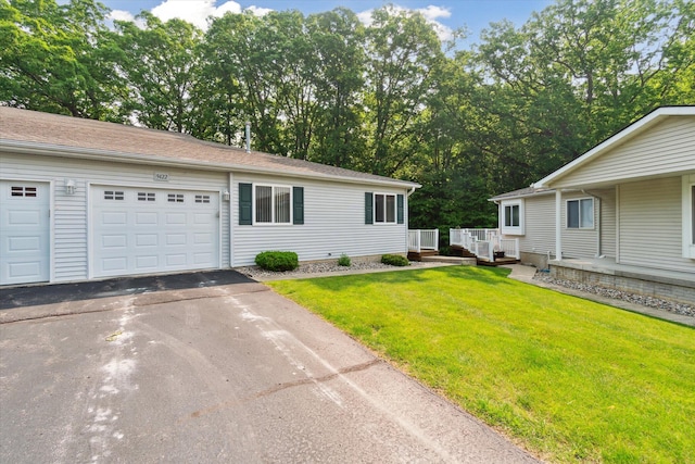 9422 Timber Ridge Dr, Grand Blanc, MI 48439 - ranch-style home featuring asphalt driveway, a front lawn, a garage, and view of scattered trees