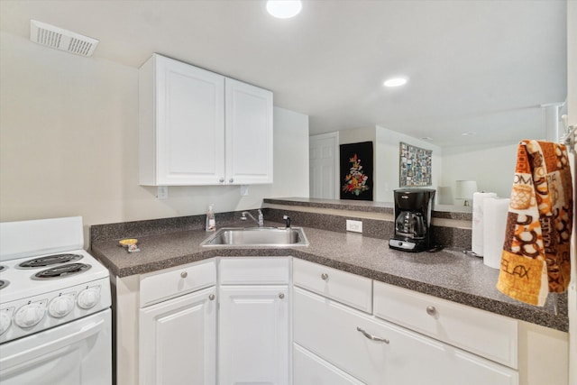 9422 Timber Ridge Dr, Grand Blanc, MI 48439 - kitchen with electric range, dark countertops, and white cabinetry