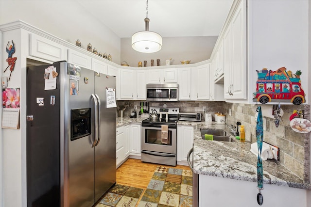 9422 Timber Ridge Dr, Grand Blanc, MI 48439 - kitchen featuring appliances with stainless steel finishes, decorative backsplash, white cabinetry, and light stone countertops