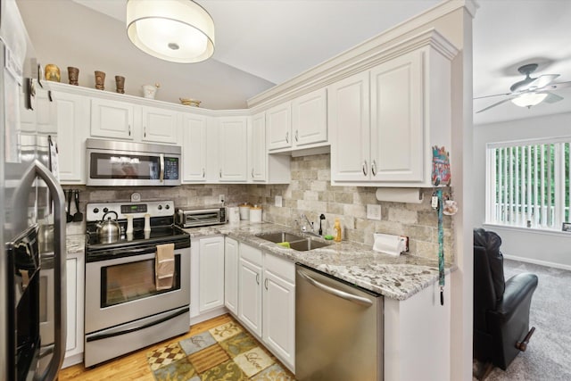 9422 Timber Ridge Dr, Grand Blanc, MI 48439 - kitchen with appliances with stainless steel finishes, tasteful backsplash, ceiling fan, vaulted ceiling, and light stone counters