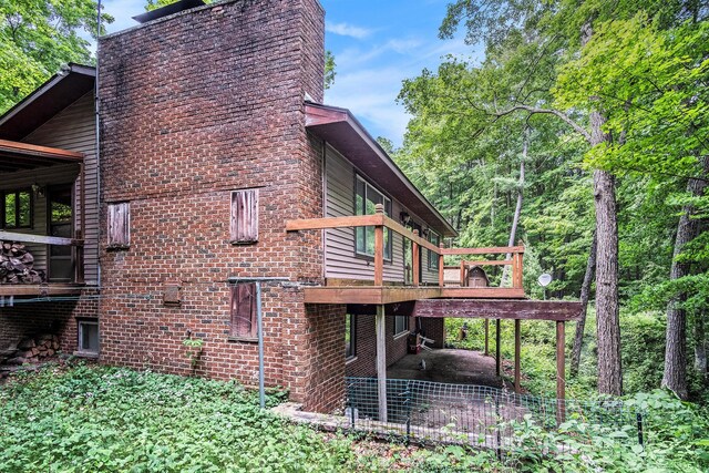 4424 Teal Ln, Newaygo, MI 49337 - view of property exterior featuring a deck, a chimney, and brick siding
