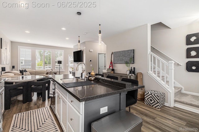 475 Jenny Way, Brighton, MI 48116 - kitchen featuring dark wood finished floors, open floor plan, an island with sink, white cabinetry, and a breakfast bar area