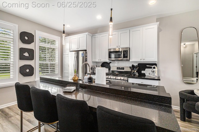 475 Jenny Way, Brighton, MI 48116 - kitchen featuring appliances with stainless steel finishes, light wood-type flooring, tasteful backsplash, a breakfast bar area, and recessed lighting