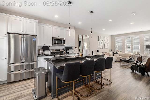 475 Jenny Way, Brighton, MI 48116 - kitchen featuring appliances with stainless steel finishes, dark countertops, light wood-style flooring, a breakfast bar, and recessed lighting