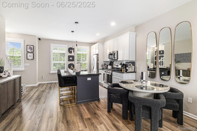 475 Jenny Way, Brighton, MI 48116 - kitchen featuring appliances with stainless steel finishes, dark countertops, dark wood-type flooring, white cabinetry, and a center island