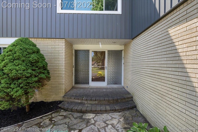 291 N Baldwin Rd, Clarkston, MI 48348 - doorway to property featuring brick siding and board and batten siding