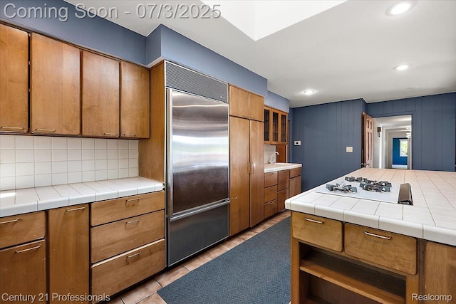 291 N Baldwin Rd, Clarkston, MI 48348 - kitchen with stainless steel built in fridge, white gas cooktop, decorative backsplash, brown cabinets, and recessed lighting