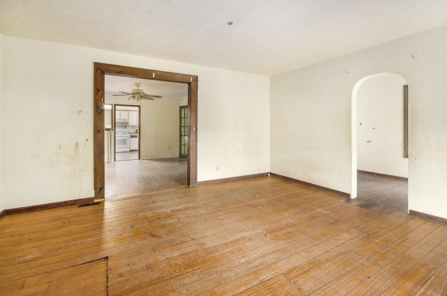 9563 Oak Rd, Willis, MI 48191 - empty room with arched walkways, light wood-style flooring, and a ceiling fan