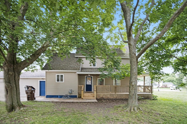1003 Masonic Ave, Belding, MI 48809 - back of house featuring a porch, a shingled roof, and a lawn