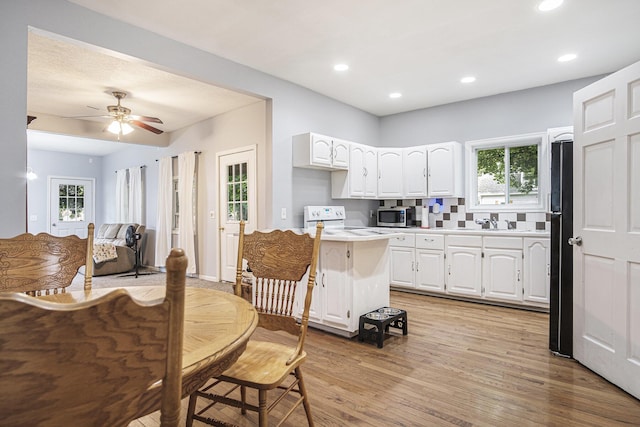 1003 Masonic Ave, Belding, MI 48809 - kitchen featuring stainless steel microwave, light countertops, white cabinetry, light wood-style flooring, and ceiling fan