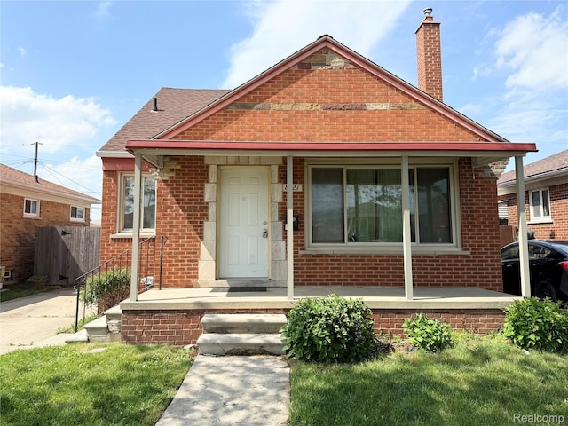 8121 Marian St, Warren, MI 48093 - bungalow-style house featuring brick siding, a chimney, a porch, and roof with shingles