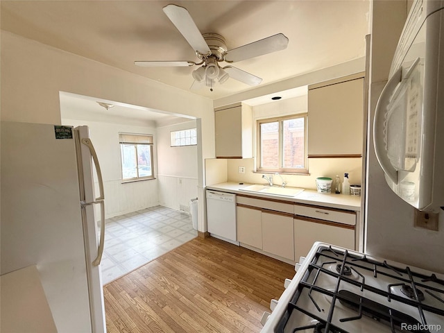 8121 Marian St, Warren, MI 48093 - kitchen with white appliances, light countertops, wainscoting, ceiling fan, and light flooring