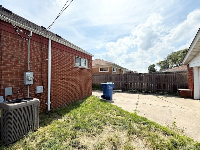 8121 Marian St, Warren, MI 48093 - view of home's exterior with brick siding, a patio area, and roof with shingles