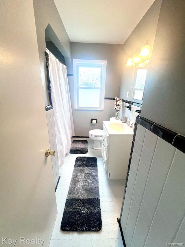 13509 Backus St, Southgate, MI 48195 - bathroom featuring vanity, tile walls, plenty of natural light, wainscoting, and shower / bath combo with shower curtain