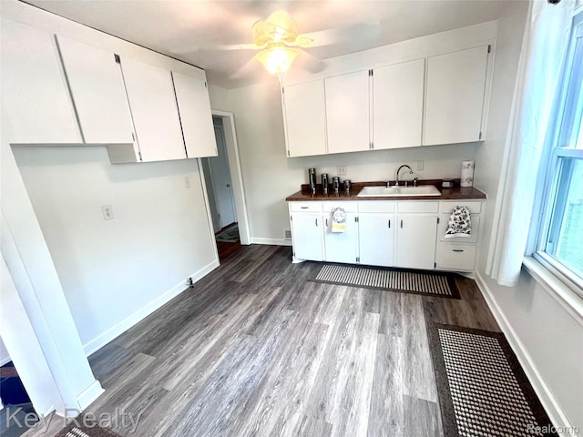 13509 Backus St, Southgate, MI 48195 - kitchen featuring dark wood-type flooring, dark countertops, and white cabinets