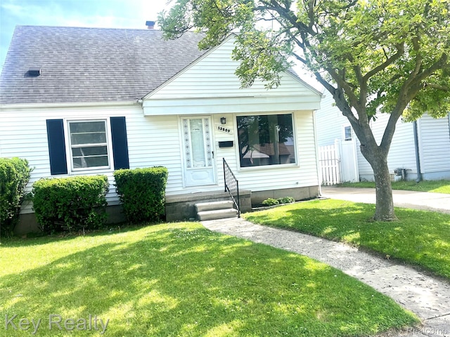 13509 Backus St, Southgate, MI 48195 - view of front of home featuring a shingled roof and a front lawn
