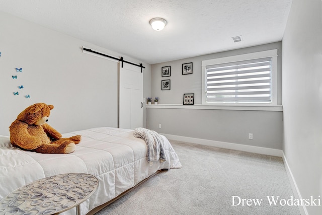 8205 Autumn Acres Dr, Rockford, MI 49341 - bedroom featuring a barn door, carpet floors, and a textured ceiling