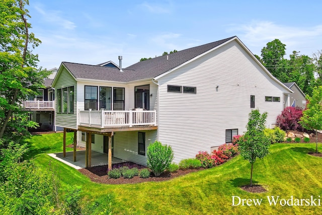 8205 Autumn Acres Dr, Rockford, MI 49341 - rear view of house featuring a patio, a yard, a wooden deck, and a shingled roof