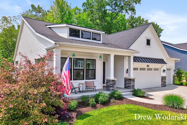 8205 Autumn Acres Dr, Rockford, MI 49341 - view of front of home featuring a porch, concrete driveway, a garage, a shingled roof, and stone siding