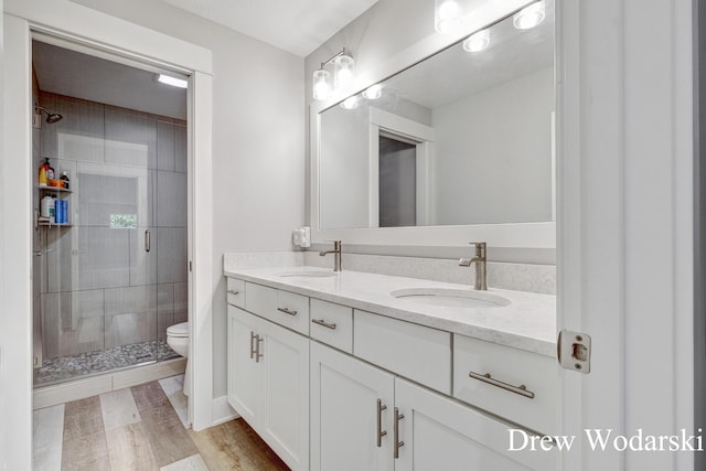 8205 Autumn Acres Dr, Rockford, MI 49341 - full bathroom featuring double vanity, a shower stall, and wood finished floors