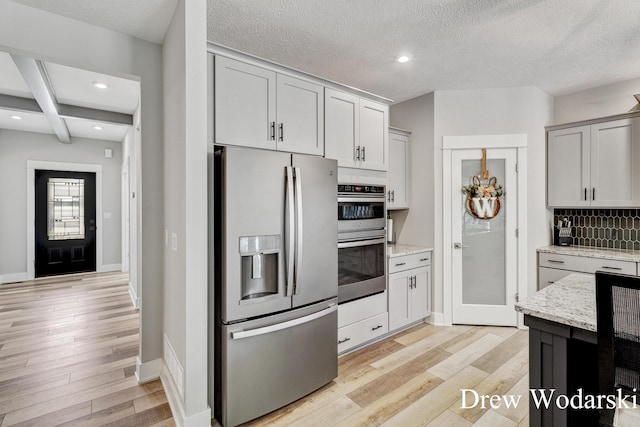 8205 Autumn Acres Dr, Rockford, MI 49341 - kitchen with appliances with stainless steel finishes, light wood-type flooring, backsplash, light stone countertops, and recessed lighting