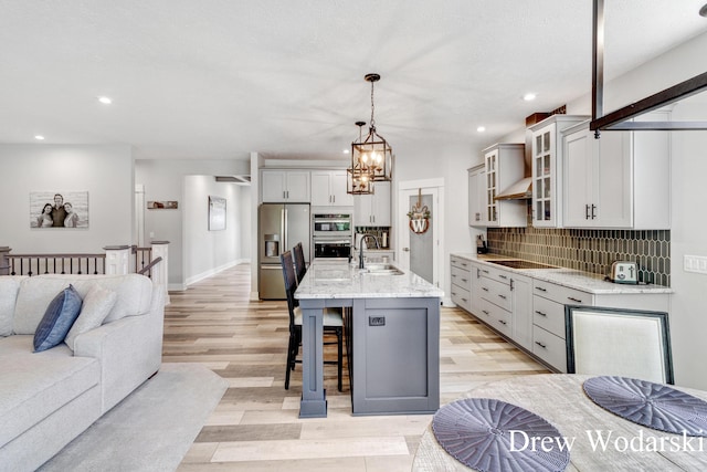 8205 Autumn Acres Dr, Rockford, MI 49341 - kitchen featuring stainless steel appliances, light wood-style floors, open floor plan, a kitchen bar, and recessed lighting