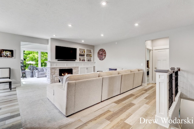 8205 Autumn Acres Dr, Rockford, MI 49341 - living room with light wood-type flooring, a fireplace, recessed lighting, and a textured ceiling