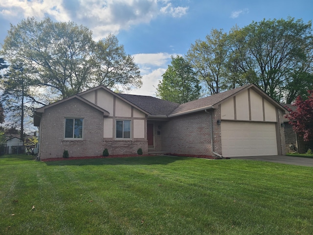 3393 Kevin Cir, Warren, MI 48092 - english style home featuring a garage, driveway, a front yard, and brick siding
