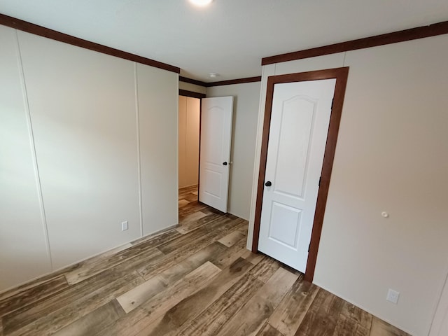 770 129th Ave Unit 4, Shelbyville, MI 49344 - unfurnished bedroom with wood finished floors and ornamental molding