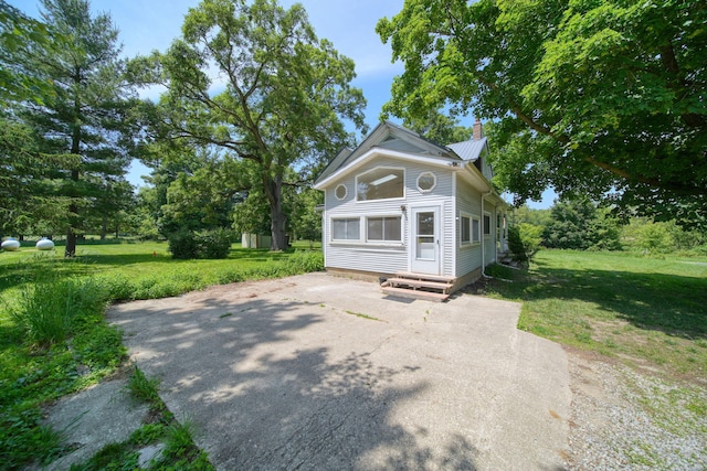 15379 Howard Rd, Hanover, MI 49241 - view of front of house featuring a chimney, entry steps, a front lawn, and driveway