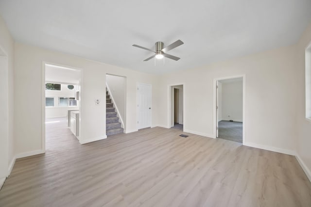15379 Howard Rd, Hanover, MI 49241 - unfurnished living room featuring ceiling fan, light wood finished floors, and stairway