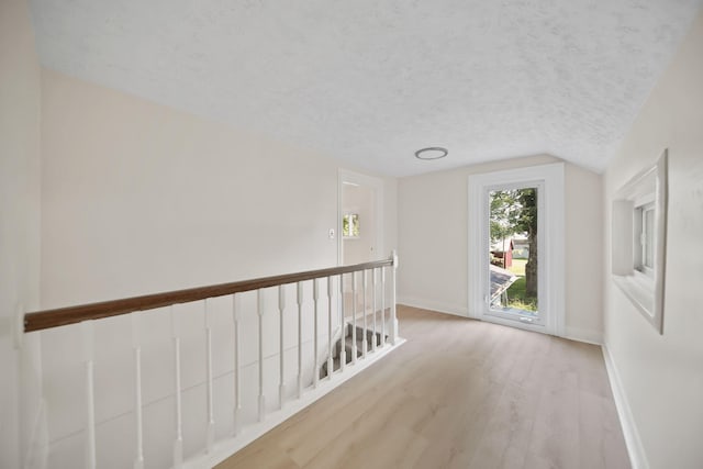 15379 Howard Rd, Hanover, MI 49241 - hall with wood finished floors, lofted ceiling, an upstairs landing, and a textured ceiling