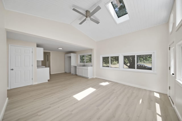 15379 Howard Rd, Hanover, MI 49241 - unfurnished living room featuring a ceiling fan, vaulted ceiling, a skylight, and light wood-style flooring