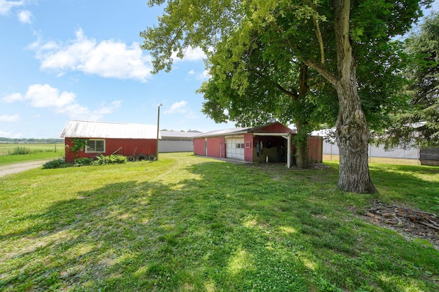 15379 Howard Rd, Hanover, MI 49241 - view of green lawn with a pole building, a detached garage, and an outbuilding