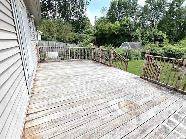 5425 Westchester Dr, Flint, MI 48532 - wooden deck featuring a fenced backyard, view of scattered trees, and an outdoor structure