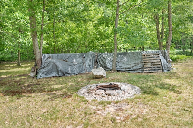 122 Canyon Rd, Leroy, MI 49655 - view of grassy yard with an outdoor fire pit and a wooded view