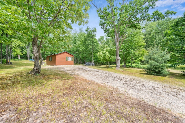 122 Canyon Rd, Leroy, MI 49655 - view of green lawn with dirt driveway and view of wooded area