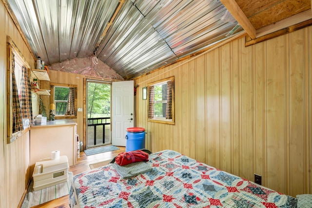 122 Canyon Rd, Leroy, MI 49655 - bedroom featuring access to outside, wood walls, and vaulted ceiling