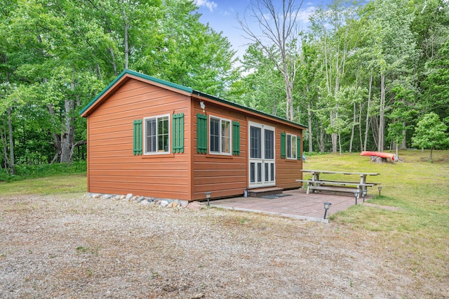 122 Canyon Rd, Leroy, MI 49655 - view of property exterior with an outbuilding, a yard, a deck, and view of wooded area