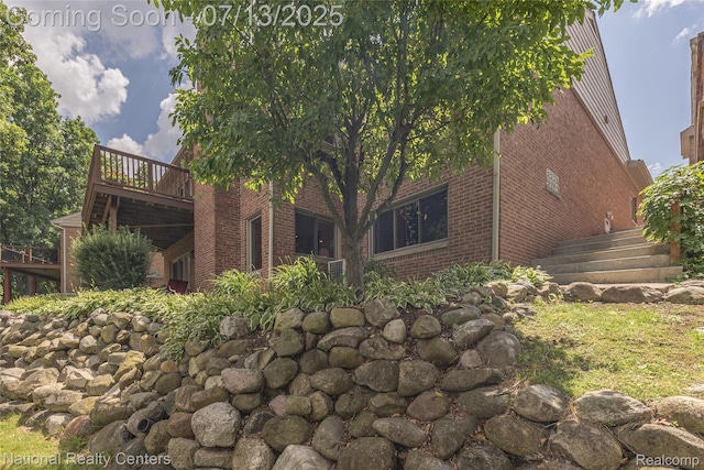 285 Ash Ct, South Lyon, MI 48178 - view of side of property with brick siding, stairway, and a wooden deck