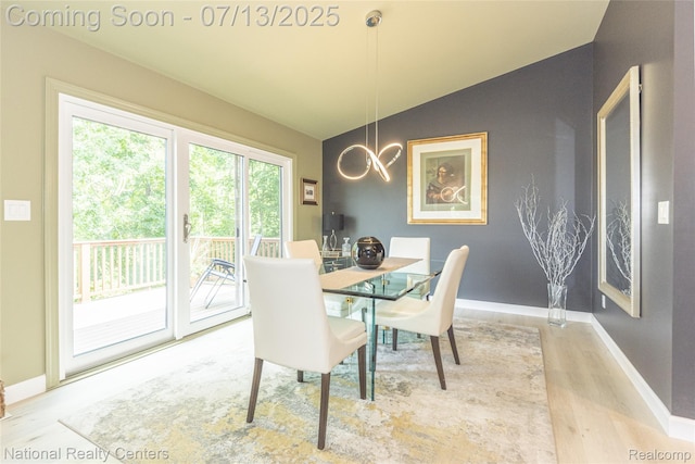 285 Ash Ct, South Lyon, MI 48178 - dining area with lofted ceiling, wood finished floors, and a chandelier