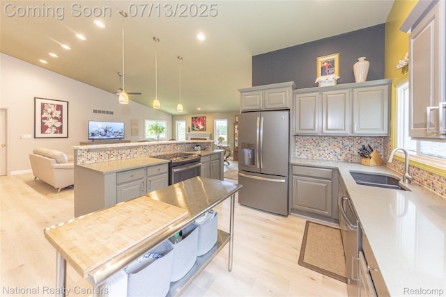 285 Ash Ct, South Lyon, MI 48178 - kitchen with stainless steel appliances, gray cabinetry, light wood-style flooring, tasteful backsplash, and healthy amount of natural light