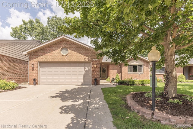 285 Ash Ct, South Lyon, MI 48178 - ranch-style home with an attached garage, driveway, brick siding, and a front yard