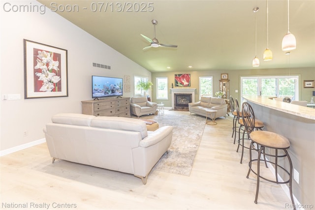285 Ash Ct, South Lyon, MI 48178 - living area with light wood finished floors, plenty of natural light, a fireplace, a ceiling fan, and high vaulted ceiling